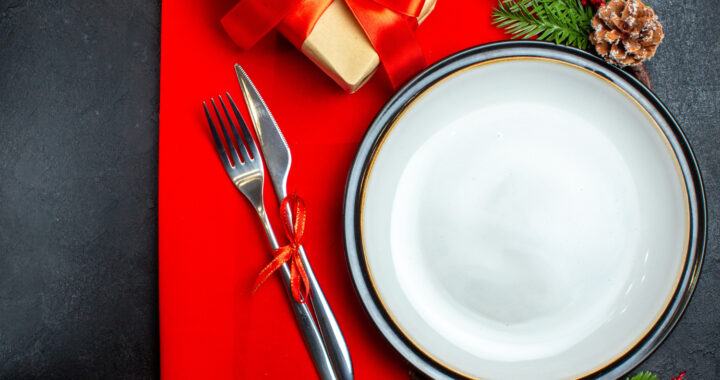 top-view-new-year-background-with-dinner-plate-cutlery-set-decoration-accessories-fir-branches-gift-red-napkin