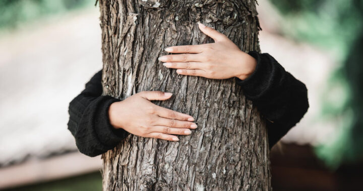 contented-young-woman-hugging-large-tree-with-blissful-expression-concept-care-environment