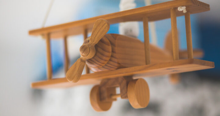 closeup-shot-wooden-miniature-old-airplane-with-blurred-background